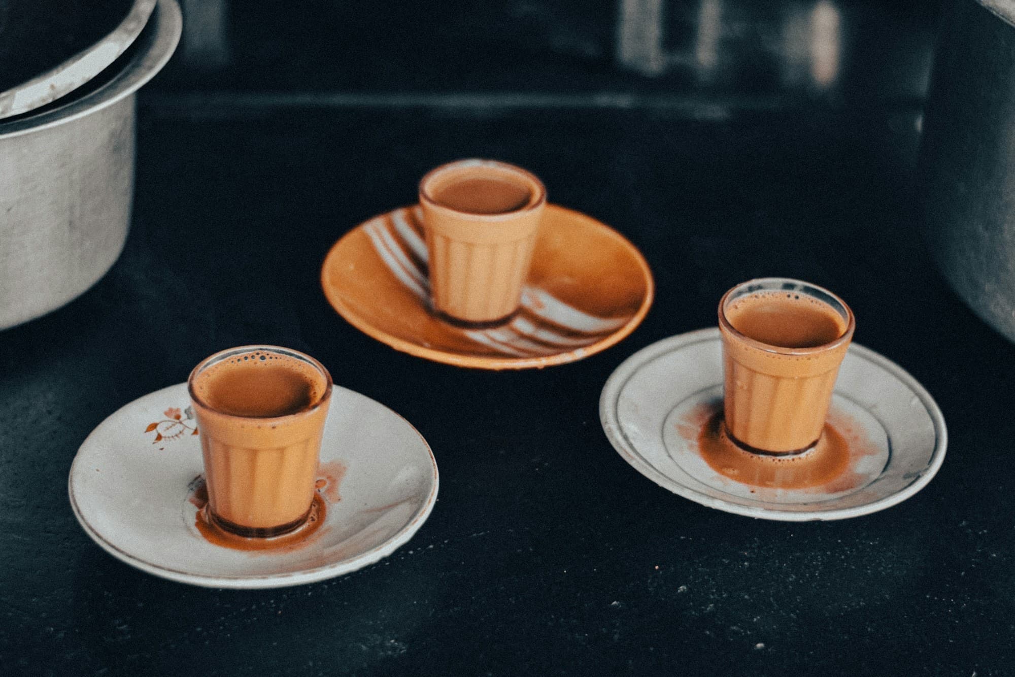 Masala chai and coffee cups on a wooden table